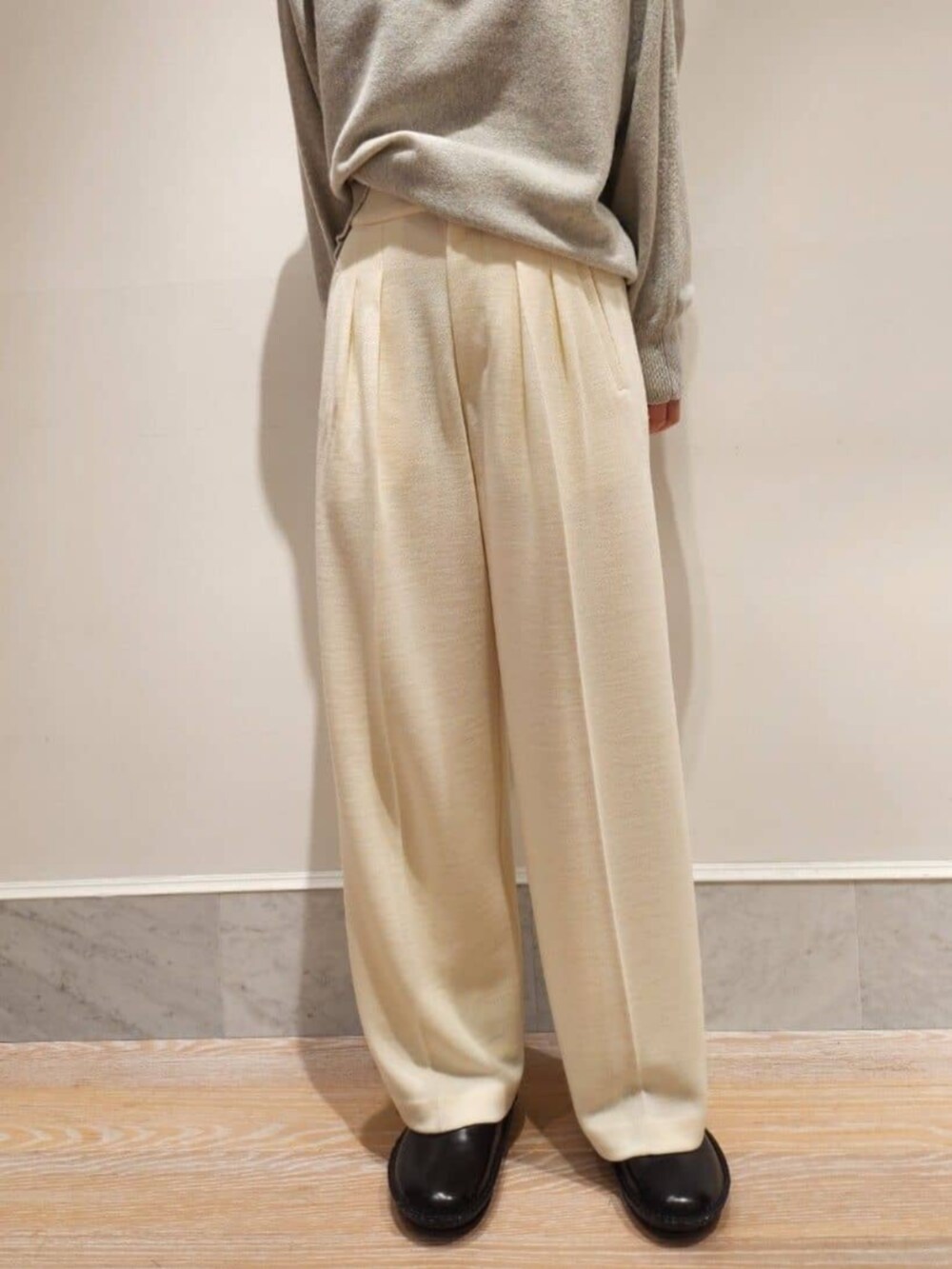 ブラック系のその他シューズ、グレー系のニット/セーター、ホワイト系のその他パンツを着用したレディースの秋コーディネートの6枚目の写真