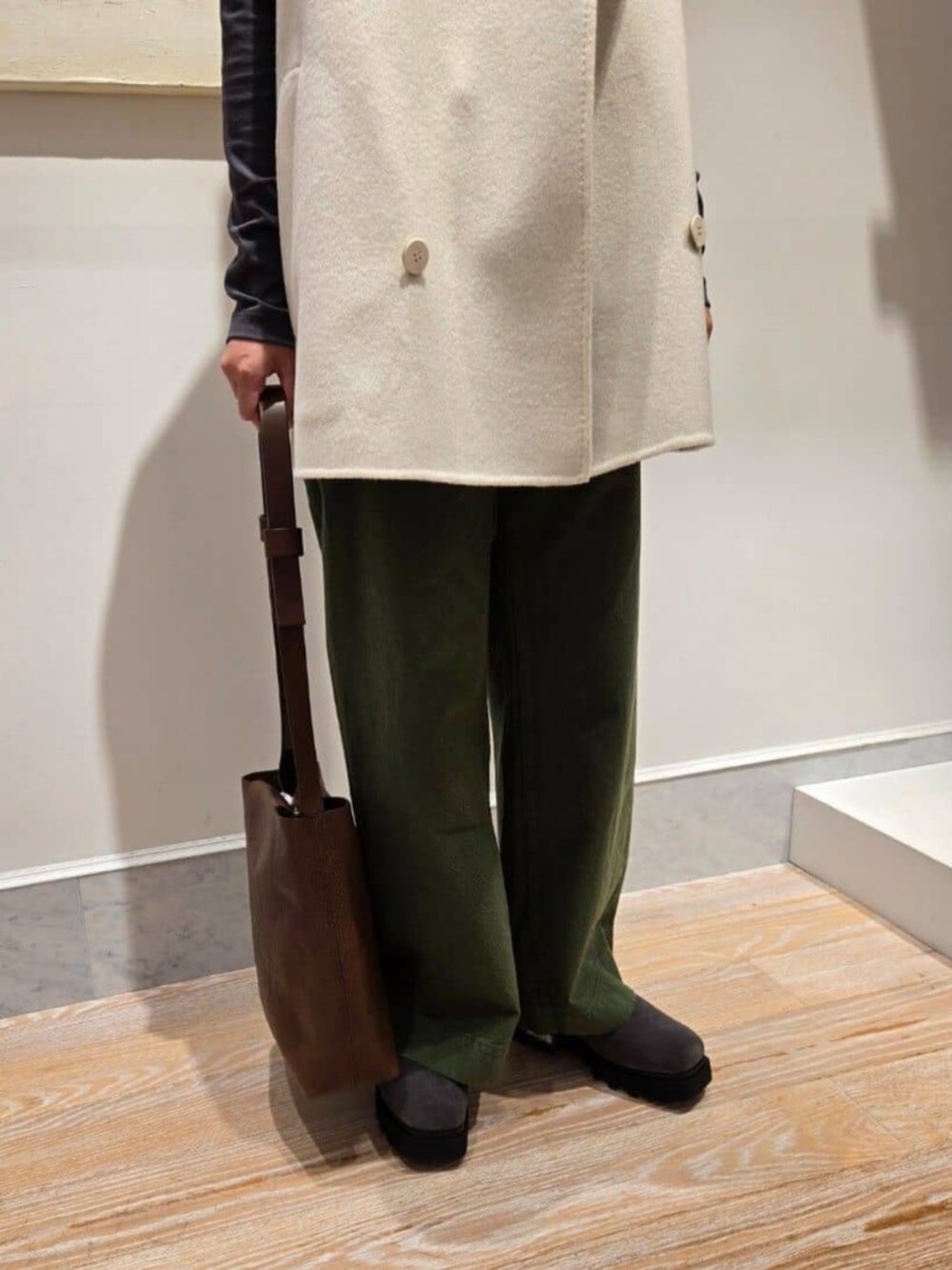 ホワイト系のベスト、グレー系のTシャツ/カットソー、ブラウン系のショルダーバッグを着用したレディースの秋コーディネートの6枚目の写真