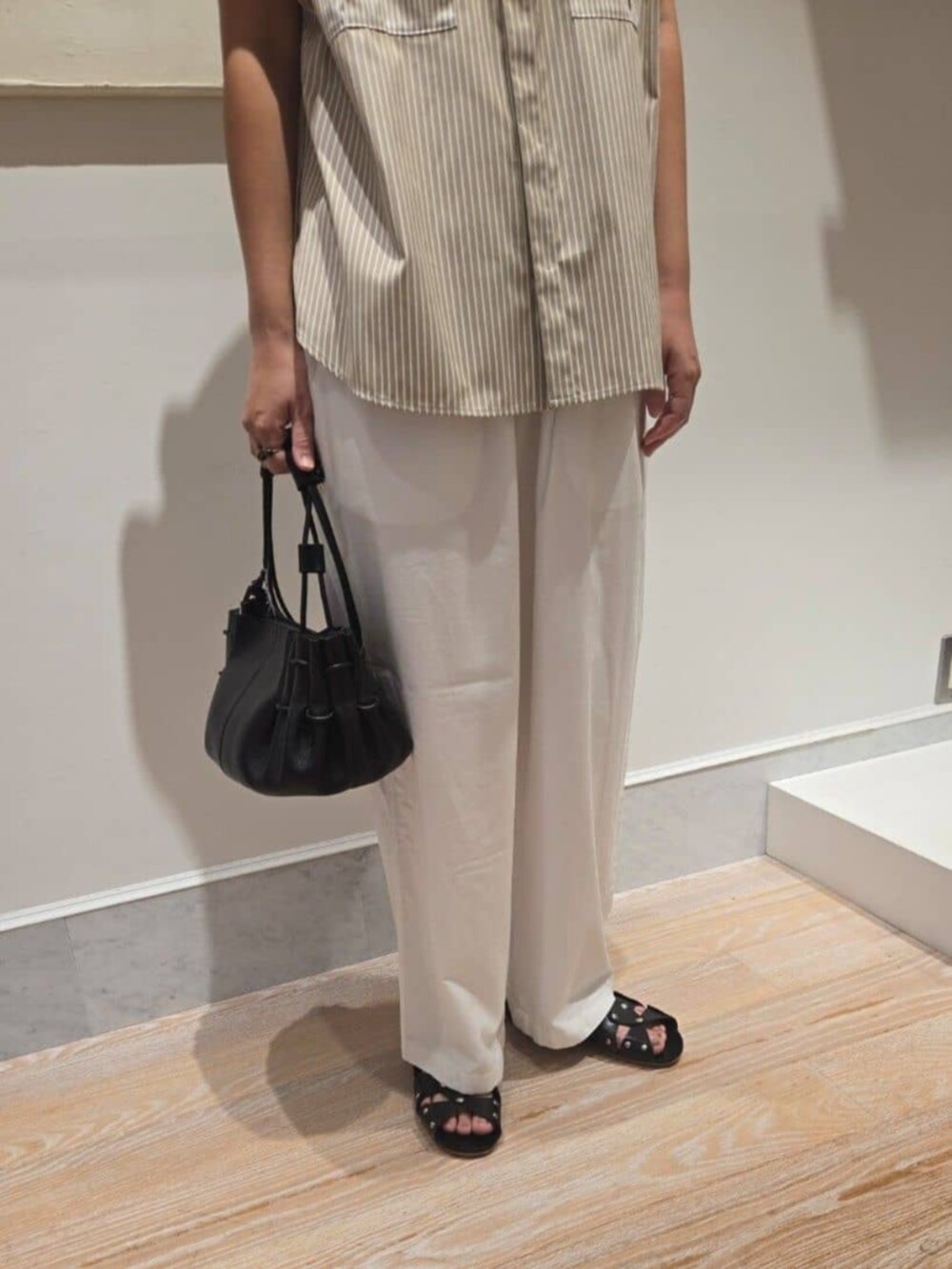 ベージュ系のシャツ/ブラウス、ホワイト系のその他パンツ、ブラック系のハンドバッグを着用したレディースの夏コーディネートの5枚目の写真