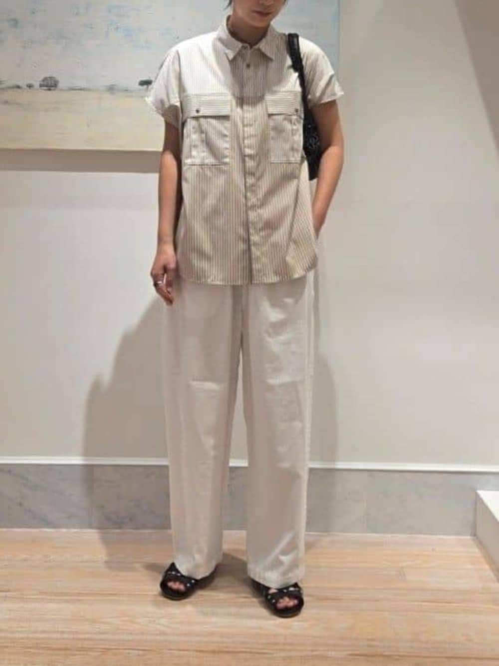 ベージュ系のシャツ/ブラウス、ホワイト系のその他パンツ、ブラック系のハンドバッグを着用したレディースの夏コーディネートの2枚目の写真