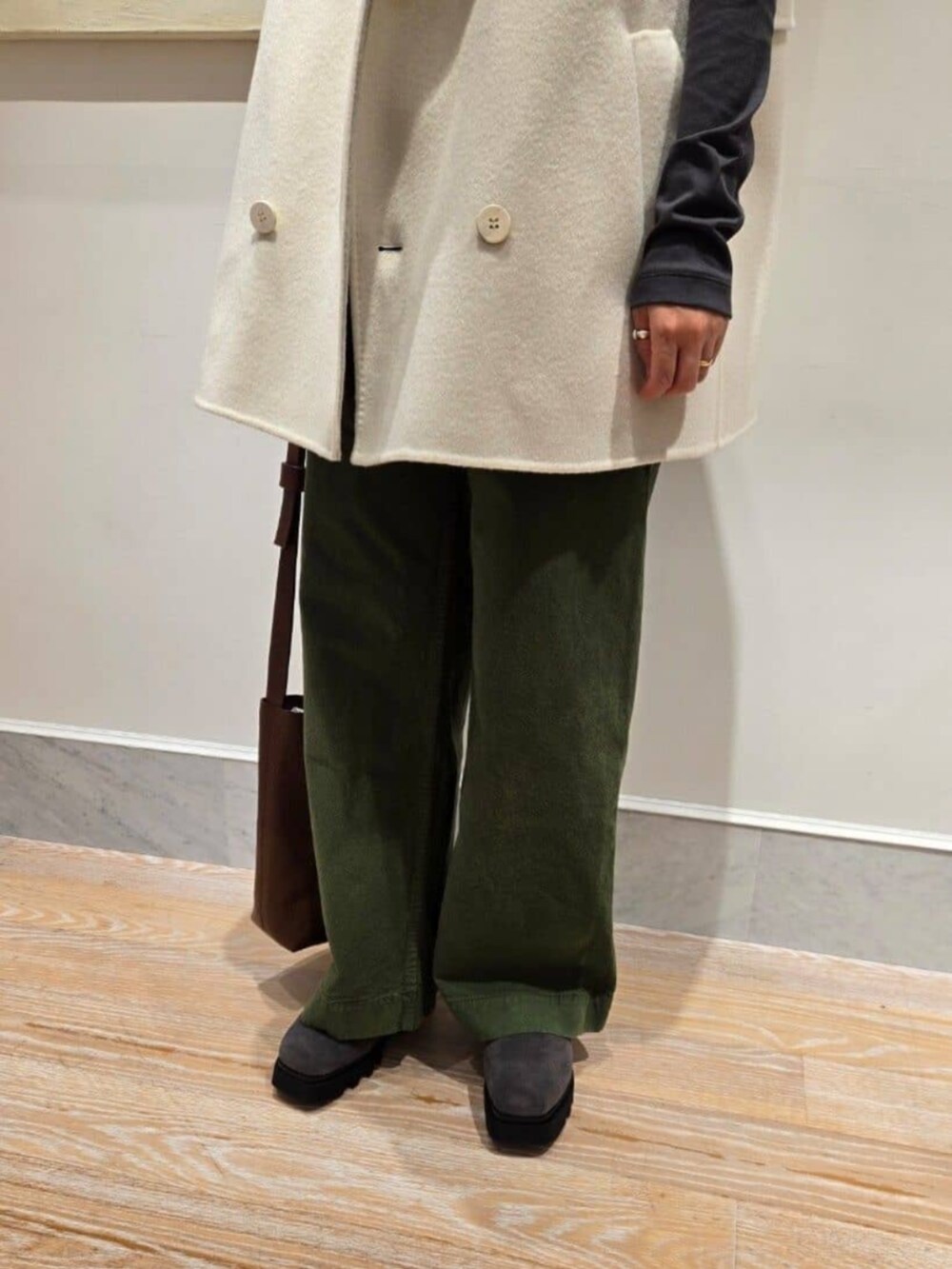 ホワイト系のベスト、グレー系のTシャツ/カットソー、ブラウン系のショルダーバッグを着用したレディースの秋コーディネートの5枚目の写真