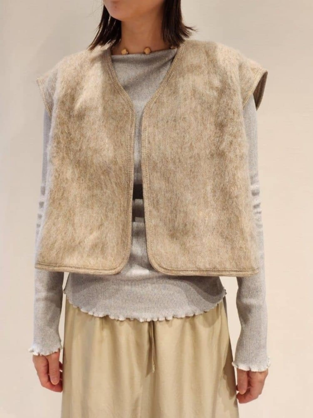 グレー系のブーツ、ベージュ系のベスト、グレー系のTシャツ/カットソーを着用したレディースの秋コーディネートの3枚目の写真