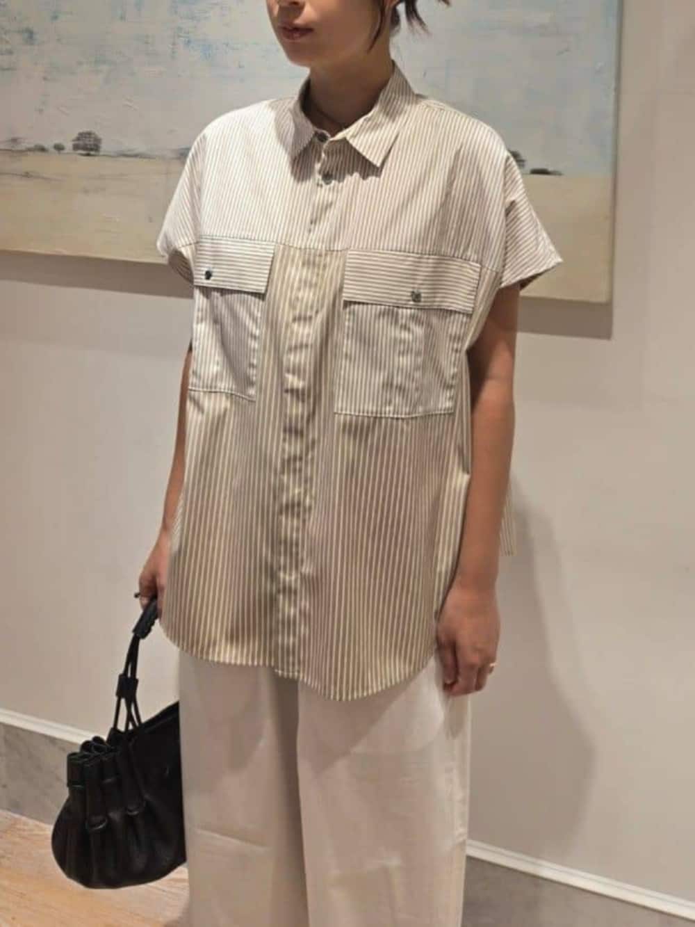 ベージュ系のシャツ/ブラウス、ホワイト系のその他パンツ、ブラック系のハンドバッグを着用したレディースの夏コーディネートの3枚目の写真