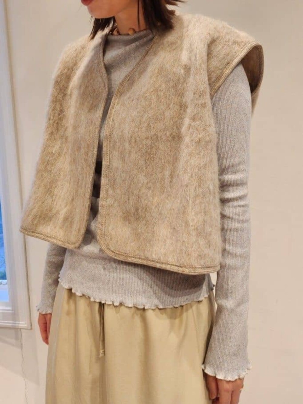 グレー系のブーツ、ベージュ系のベスト、グレー系のTシャツ/カットソーを着用したレディースの秋コーディネートの4枚目の写真