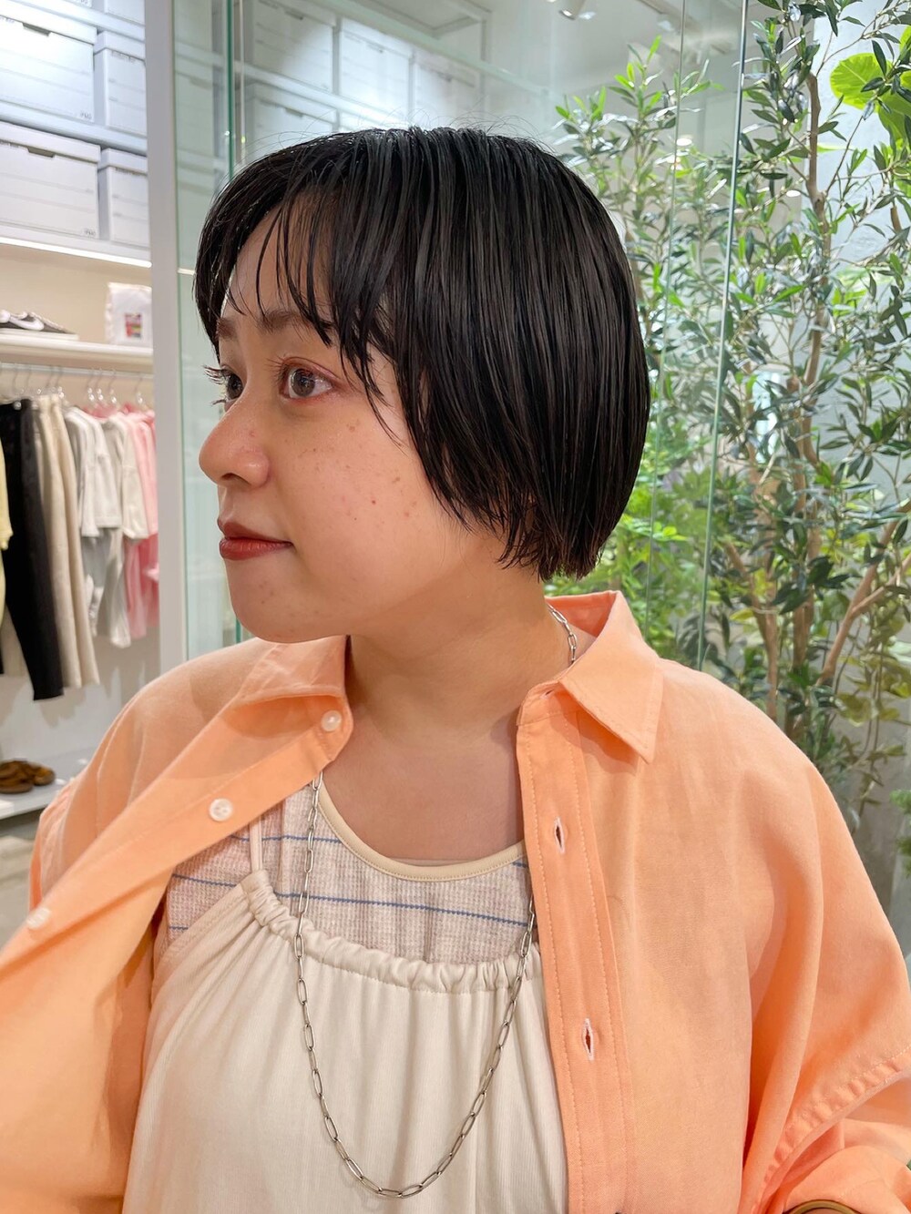 ホワイト系のワンピース、オレンジ系のシャツ/ブラウス、ベージュ系のタンクトップを着用したレディースの夏コーディネートの4枚目の写真