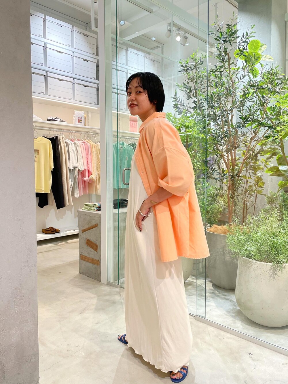 ホワイト系のワンピース、オレンジ系のシャツ/ブラウス、ベージュ系のタンクトップを着用したレディースの夏コーディネートの2枚目の写真