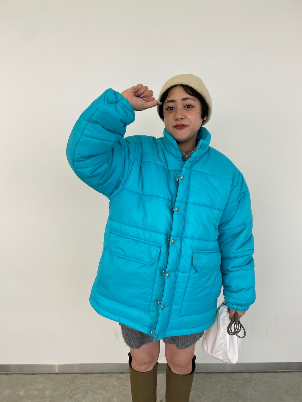 ブルー系のニット/セーター、ブルー系のダウンジャケット/コート、グレー系のその他パンツを着用したレディースの冬コーディネートの2枚目の写真