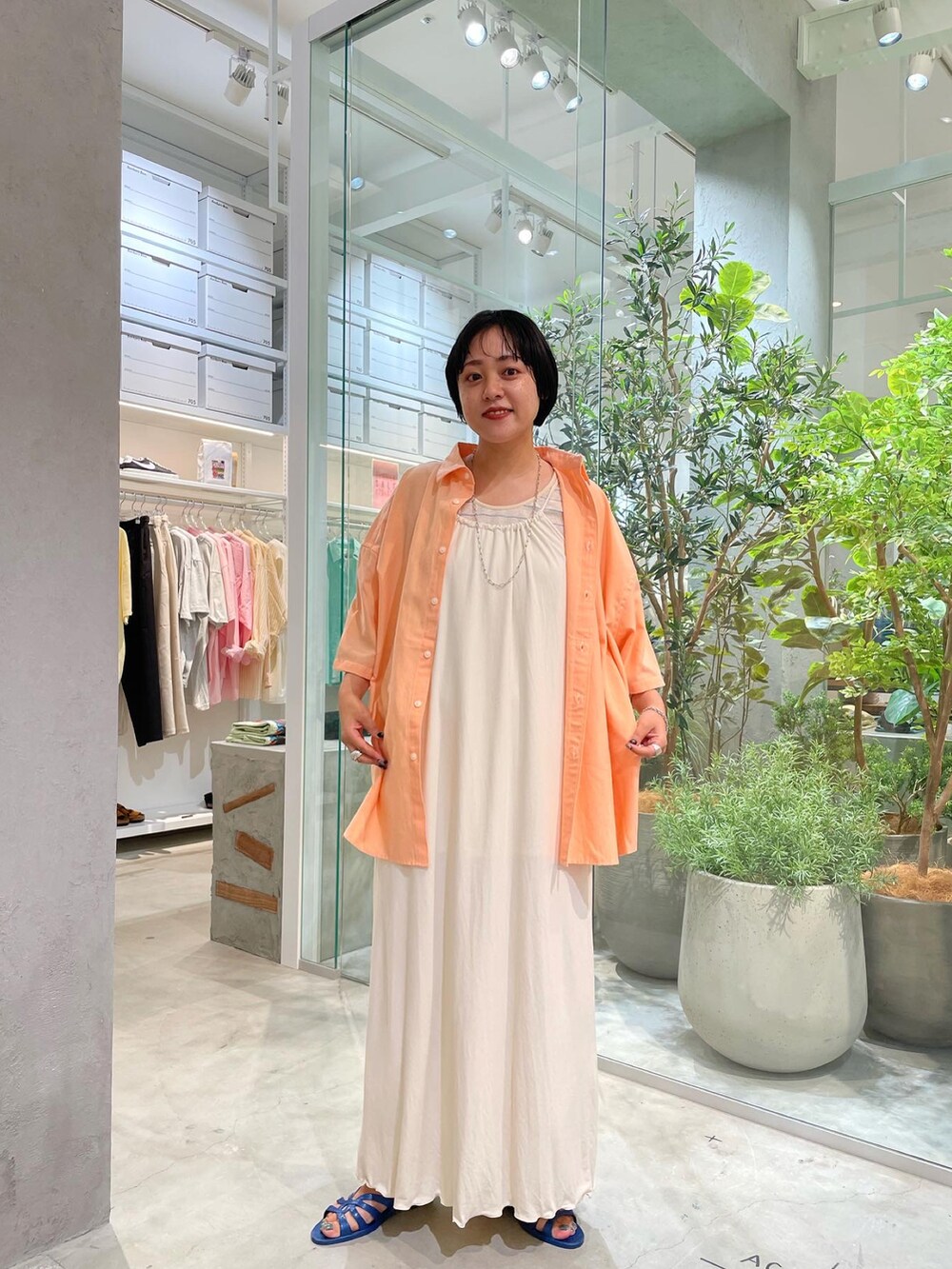 ホワイト系のワンピース、オレンジ系のシャツ/ブラウス、ベージュ系のタンクトップを着用したレディースの夏コーディネートの3枚目の写真