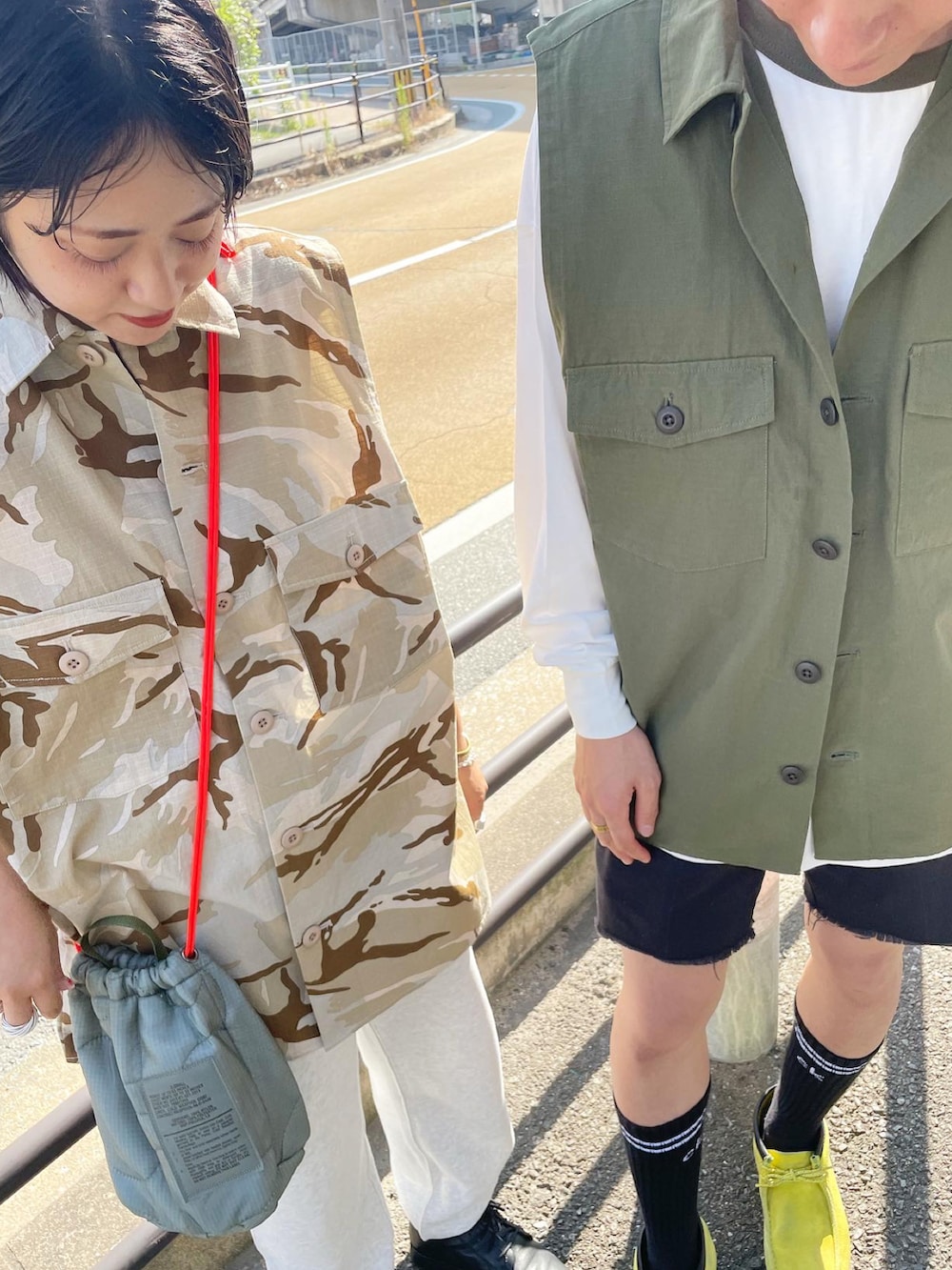 ベージュ系のベスト、グリーン系のバッグ、グレー系のスウェットパンツを着用したレディースの夏コーディネートの3枚目の写真