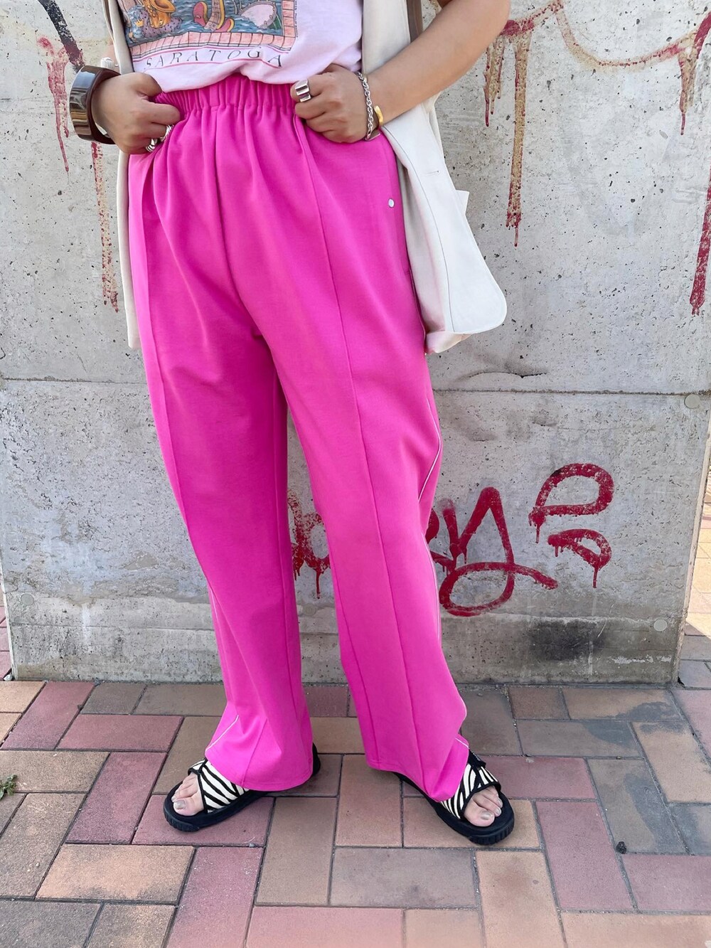 ピンク系のその他パンツ、ブラック系のサンダル、ホワイト系のベストを着用したレディースの夏コーディネートの4枚目の写真