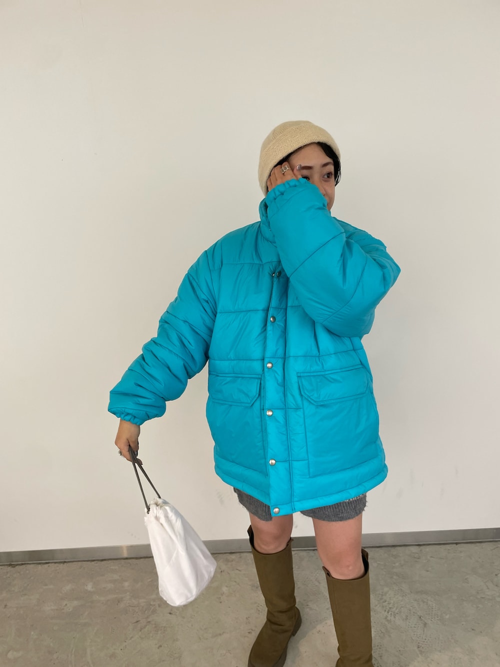 ブルー系のニット/セーター、ブルー系のダウンジャケット/コート、グレー系のその他パンツを着用したレディースの冬コーディネートの3枚目の写真
