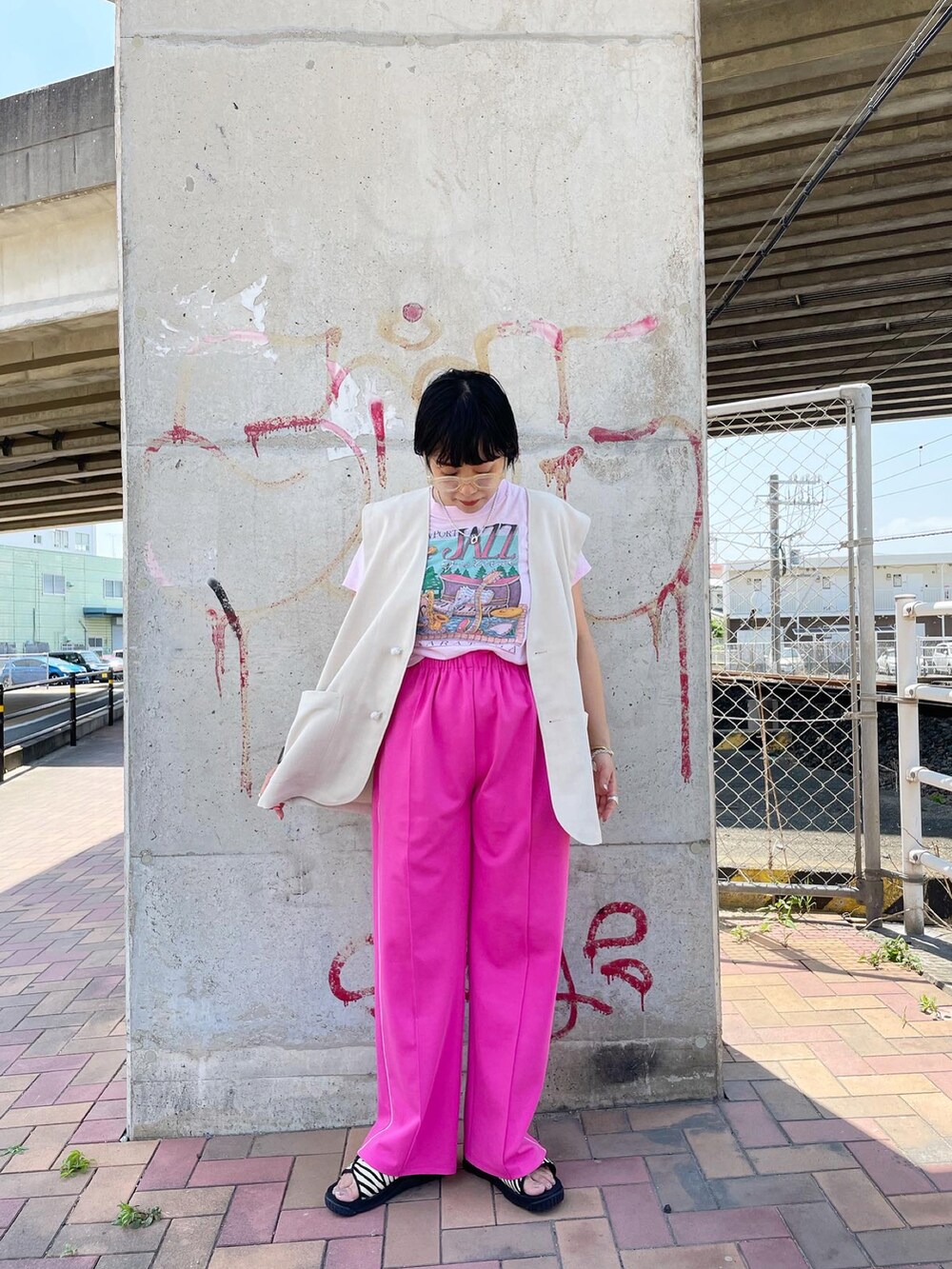 ピンク系のその他パンツ、ブラック系のサンダル、ホワイト系のベストを着用したレディースの夏コーディネートの2枚目の写真