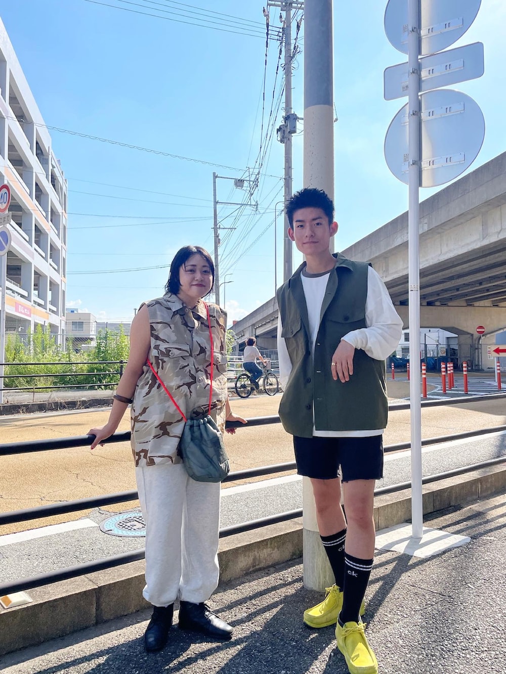 ベージュ系のベスト、グリーン系のバッグ、グレー系のスウェットパンツを着用したレディースの夏コーディネートの4枚目の写真