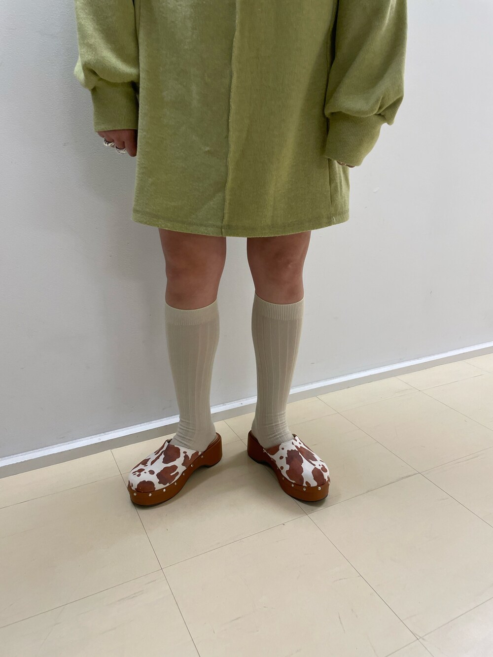 グリーン系のワンピース、ブラウン系のサンダルを着用したレディースの冬コーディネートの2枚目の写真