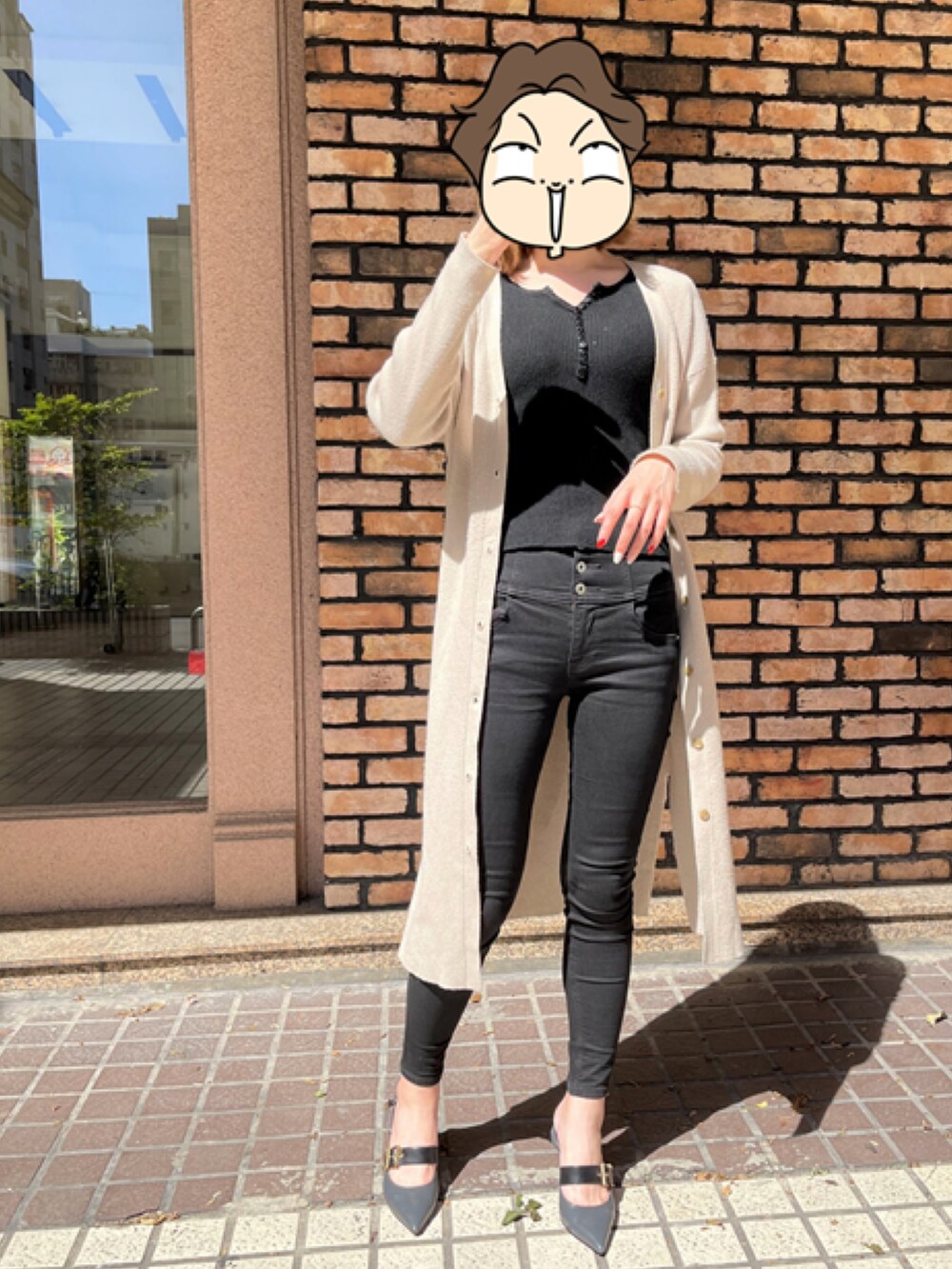 ブラック系のデニムパンツ、ベージュ系のカーディガン/ボレロ、ブルー系のパンプスを着用したレディースの春コーディネートの2枚目の写真