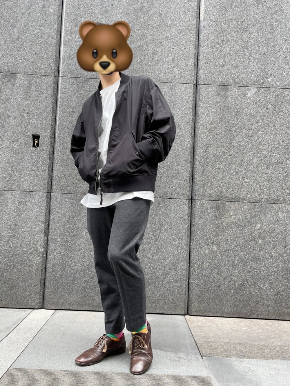 グレー系のパンツ、ブラック系のMA-1、ホワイト系のトップスを着用したメンズの春コーディネートの2枚目の写真