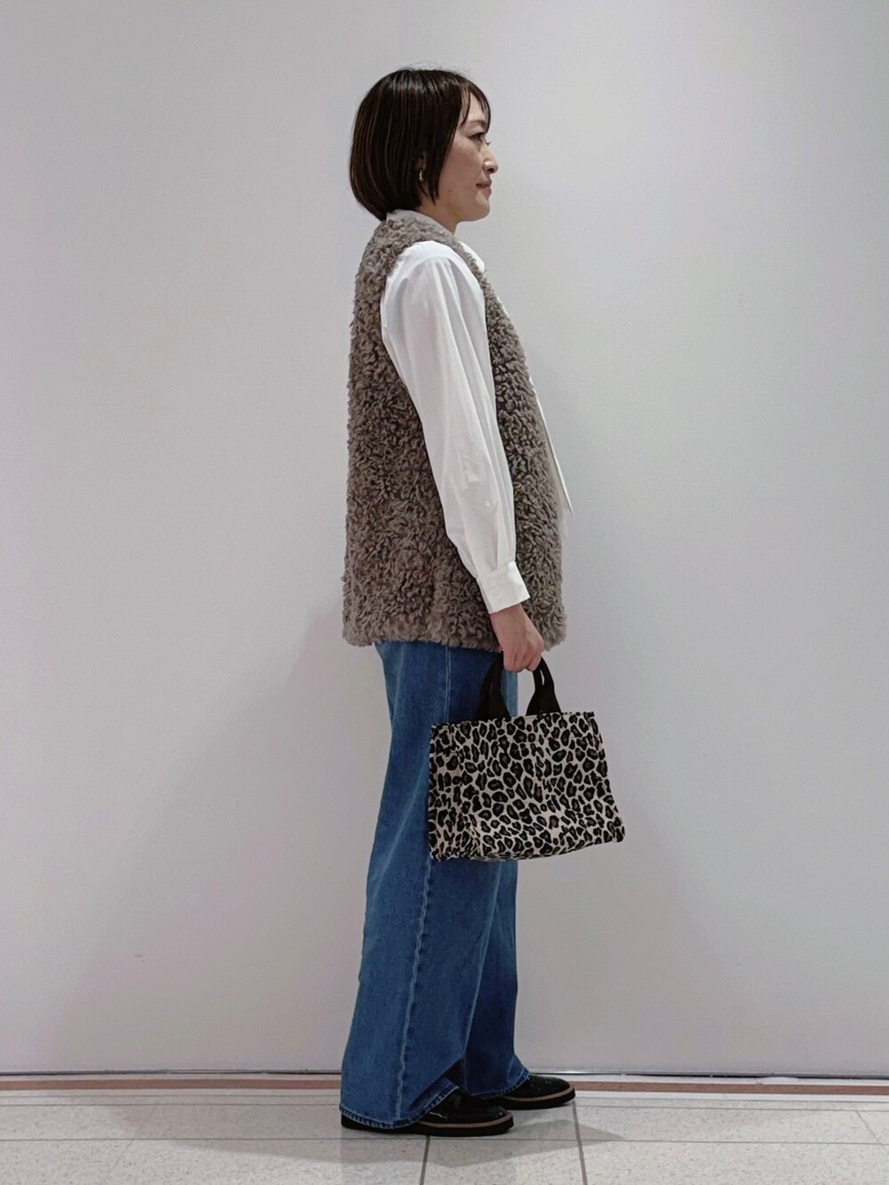 ベージュ系のベスト、ホワイト系のシャツ/ブラウス、ブルー系のその他パンツを着用したレディースの秋コーディネートの2枚目の写真