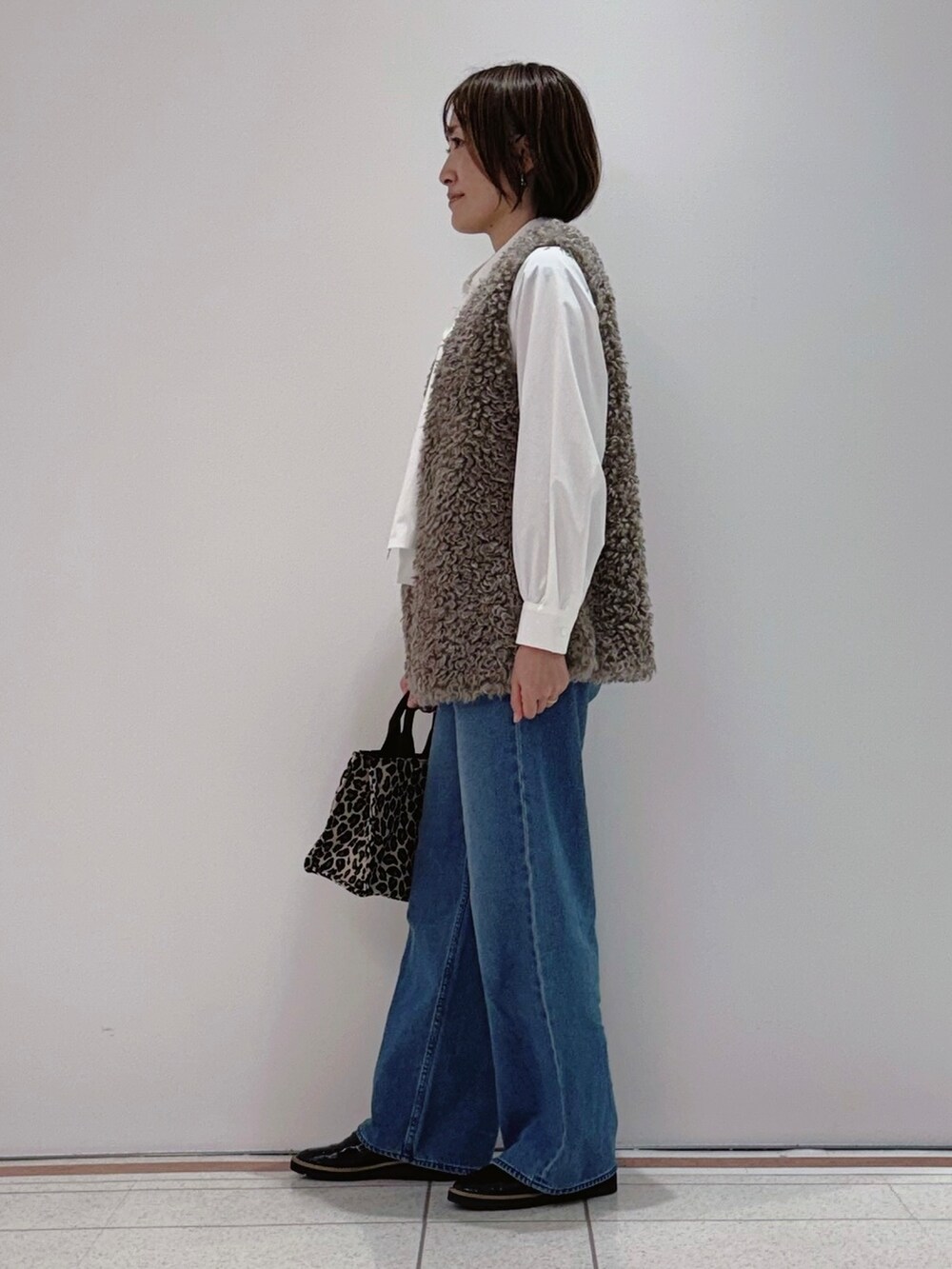 ベージュ系のベスト、ホワイト系のシャツ/ブラウス、ブルー系のその他パンツを着用したレディースの秋コーディネートの4枚目の写真