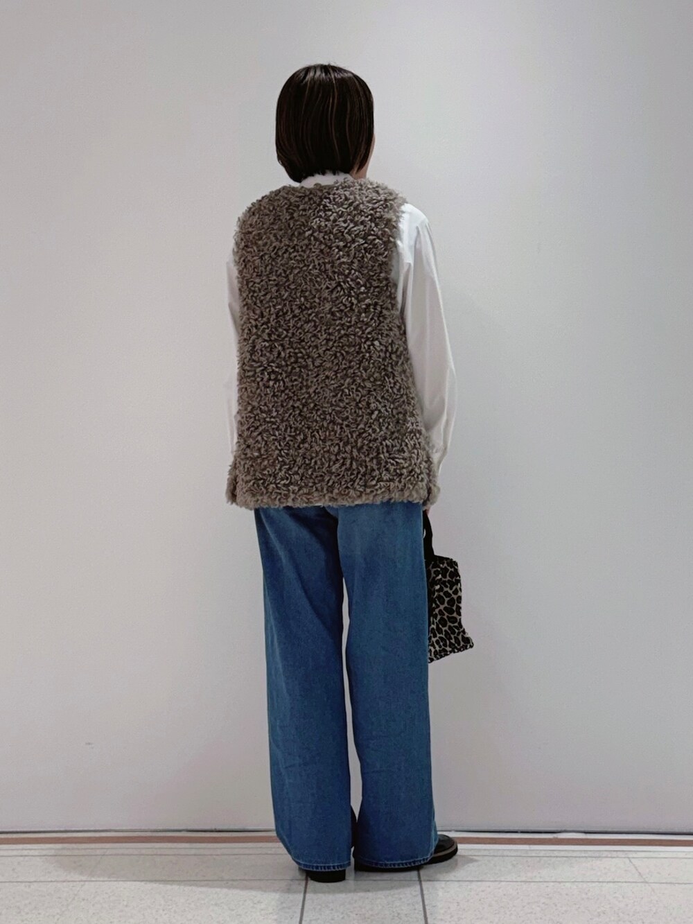 ベージュ系のベスト、ホワイト系のシャツ/ブラウス、ブルー系のその他パンツを着用したレディースの秋コーディネートの3枚目の写真