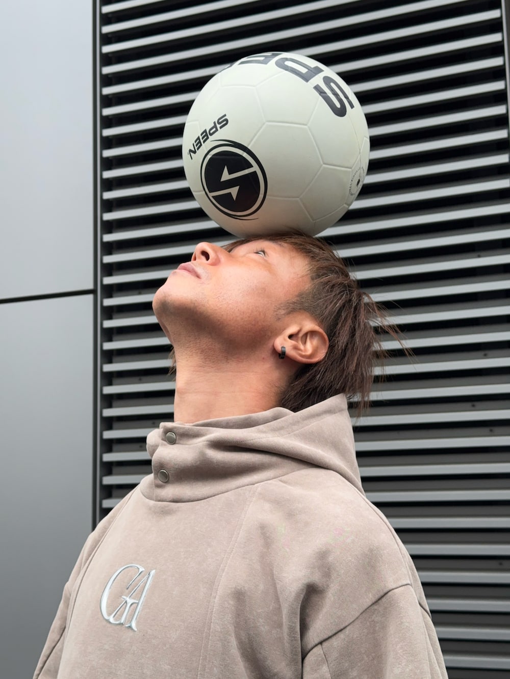 ベージュ系のパーカーを着用したメンズの春コーディネートの2枚目の写真