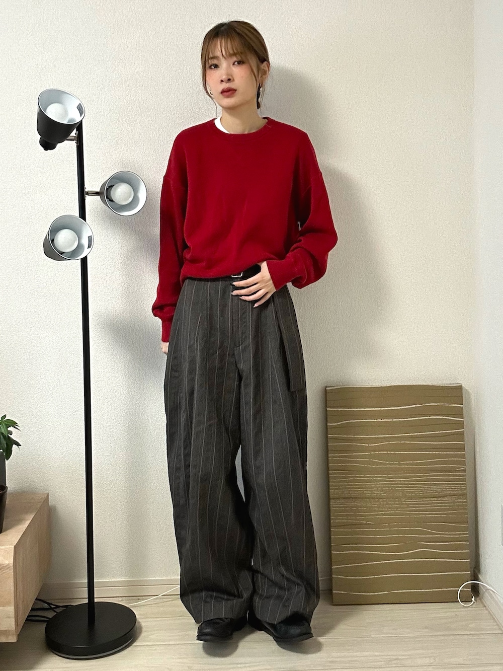 レッド系のニット/セーター、ブラウン系のパンツ、ブラック系のローファーを着用したレディースの秋コーディネートの2枚目の写真