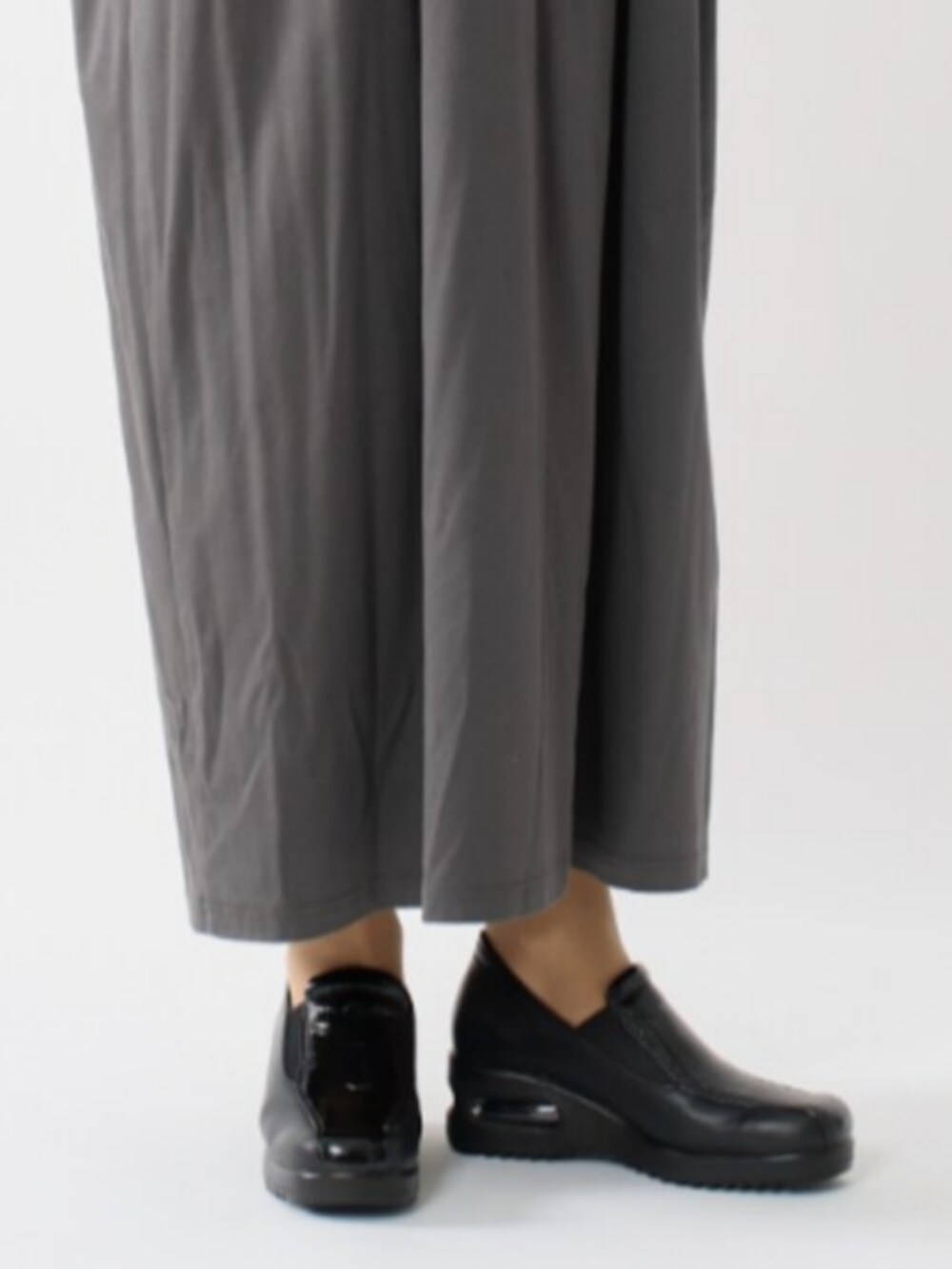 ブラック系のスリッポンを着用したレディースの春コーディネートの2枚目の写真