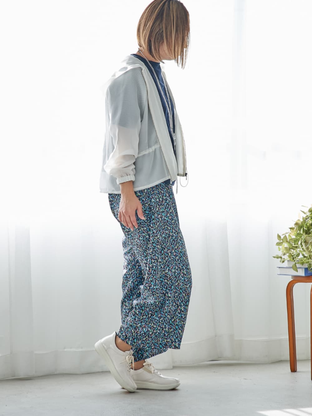 ホワイト系のスニーカーを着用したレディースの春コーディネートの2枚目の写真