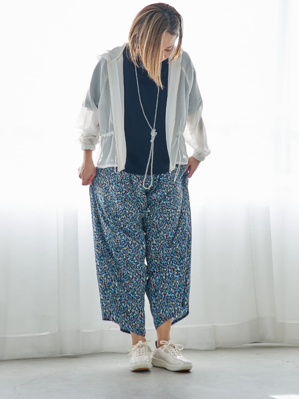 ホワイト系のスニーカーを着用したレディースの春コーディネートの3枚目の写真