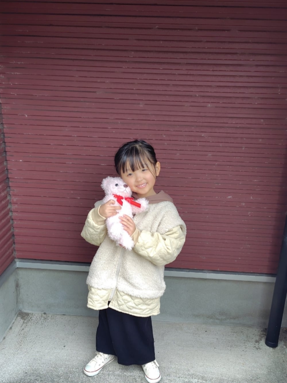 ホワイト系のその他アウター、ブラウン系のパーカー、ブラック系のスカートを着用したキッズの冬コーディネートの2枚目の写真