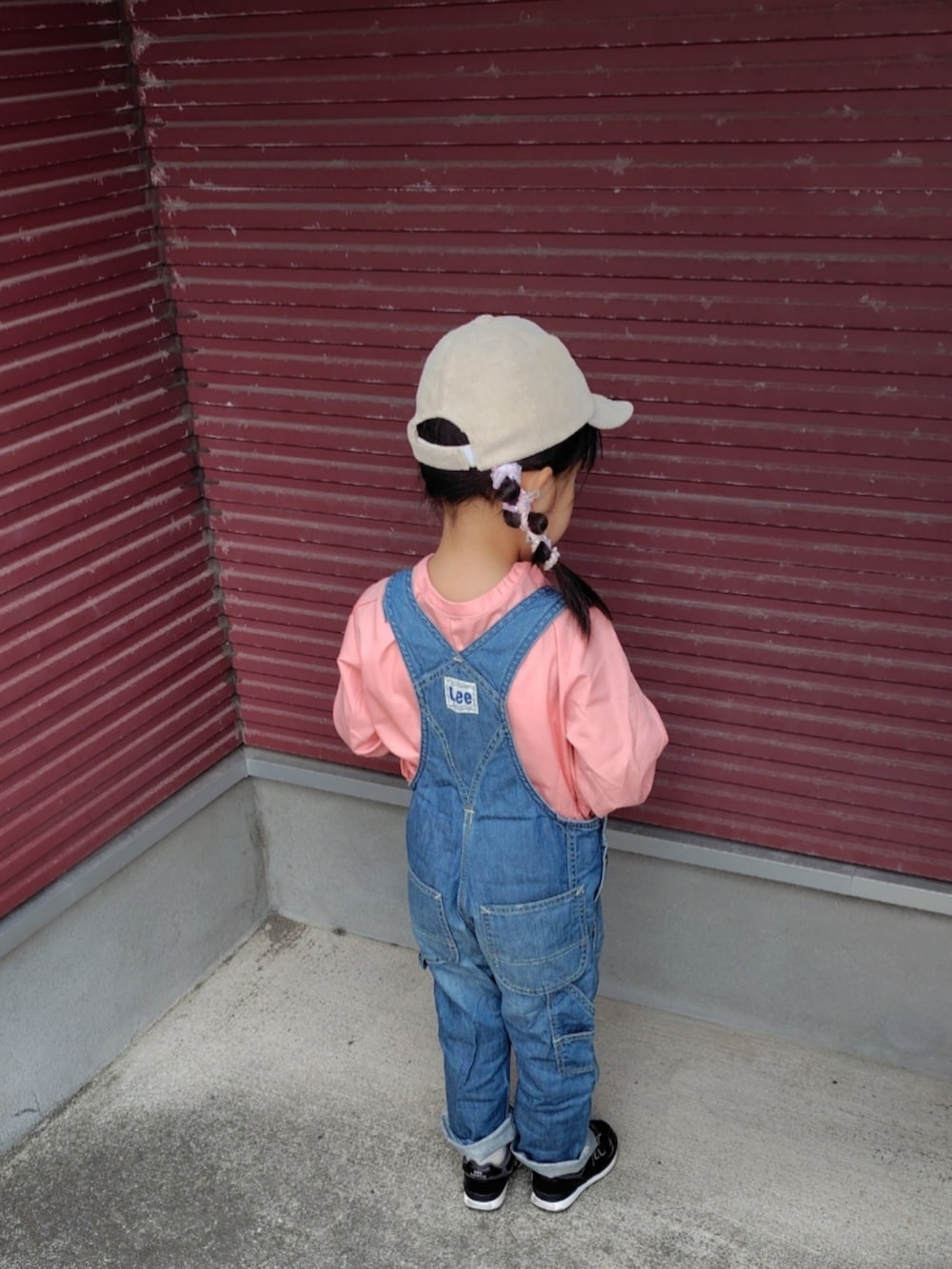 ブルー系のサロペット/オーバーオール、ピンク系のシャツ/ブラウス、ブラック系のスニーカーを着用したキッズの春コーディネートの4枚目の写真