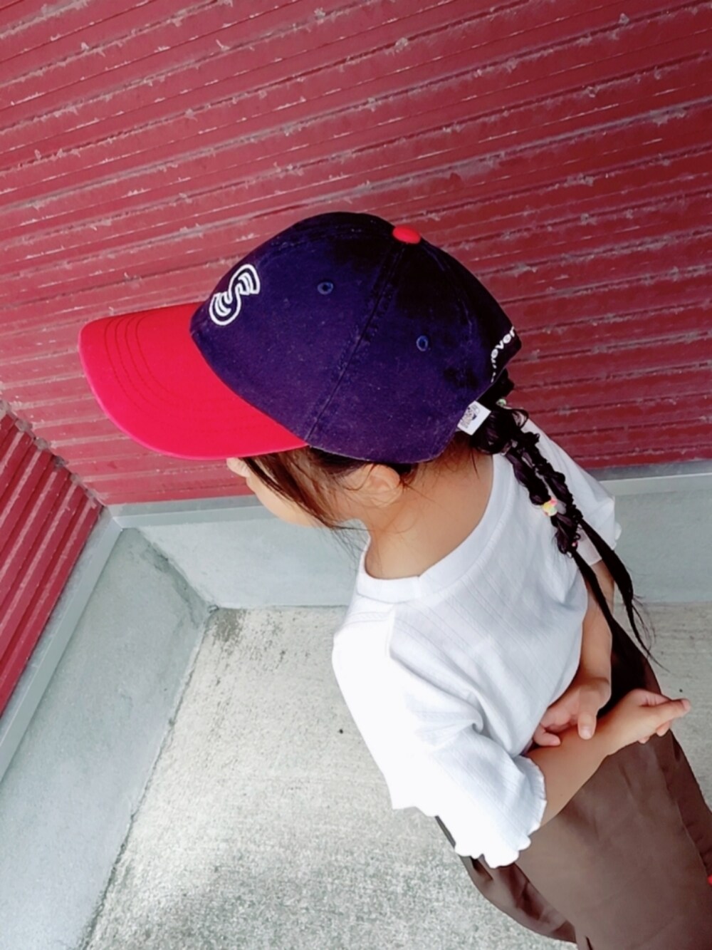 ホワイト系のTシャツ/カットソー、レッド系のスニーカー、ブルー系のキャップを着用したキッズの秋コーディネートの3枚目の写真