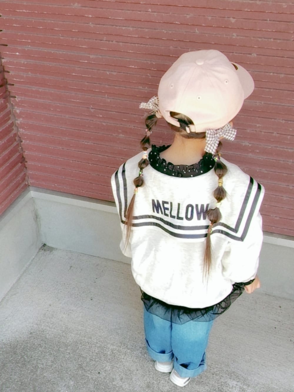 ベージュ系のスウェット、ブラック系のスカート、ブルー系のデニムパンツを着用したキッズの秋コーディネートの3枚目の写真