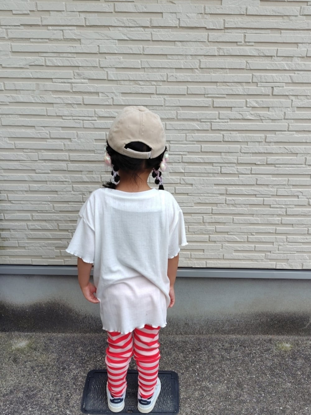 ホワイト系のTシャツ/カットソー、ホワイト系のスニーカー、レッド系のレギンス/スパッツを着用したキッズの春コーディネートの2枚目の写真