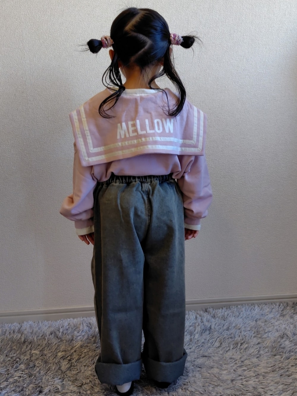 ピンク系のスウェット、ブルー系のデニムパンツ、ホワイト系のスニーカーを着用したキッズの冬コーディネートの3枚目の写真