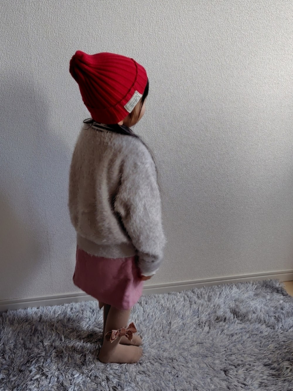 ベージュ系のカーディガン/ボレロ、ホワイト系のTシャツ/カットソー、ブラウン系のブルゾンを着用したキッズの冬コーディネートの5枚目の写真