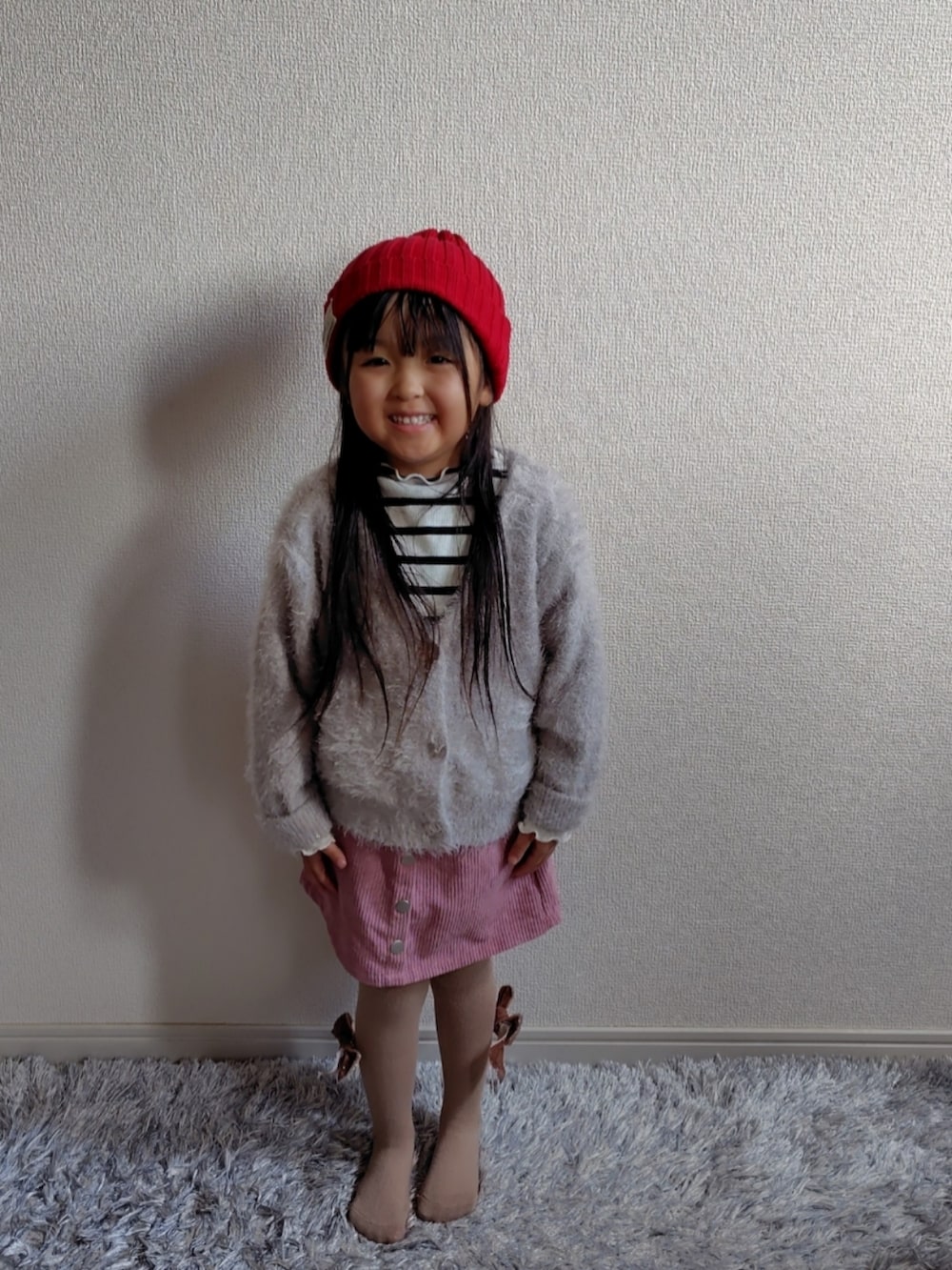 ベージュ系のカーディガン/ボレロ、ホワイト系のTシャツ/カットソー、ブラウン系のブルゾンを着用したキッズの冬コーディネートの4枚目の写真