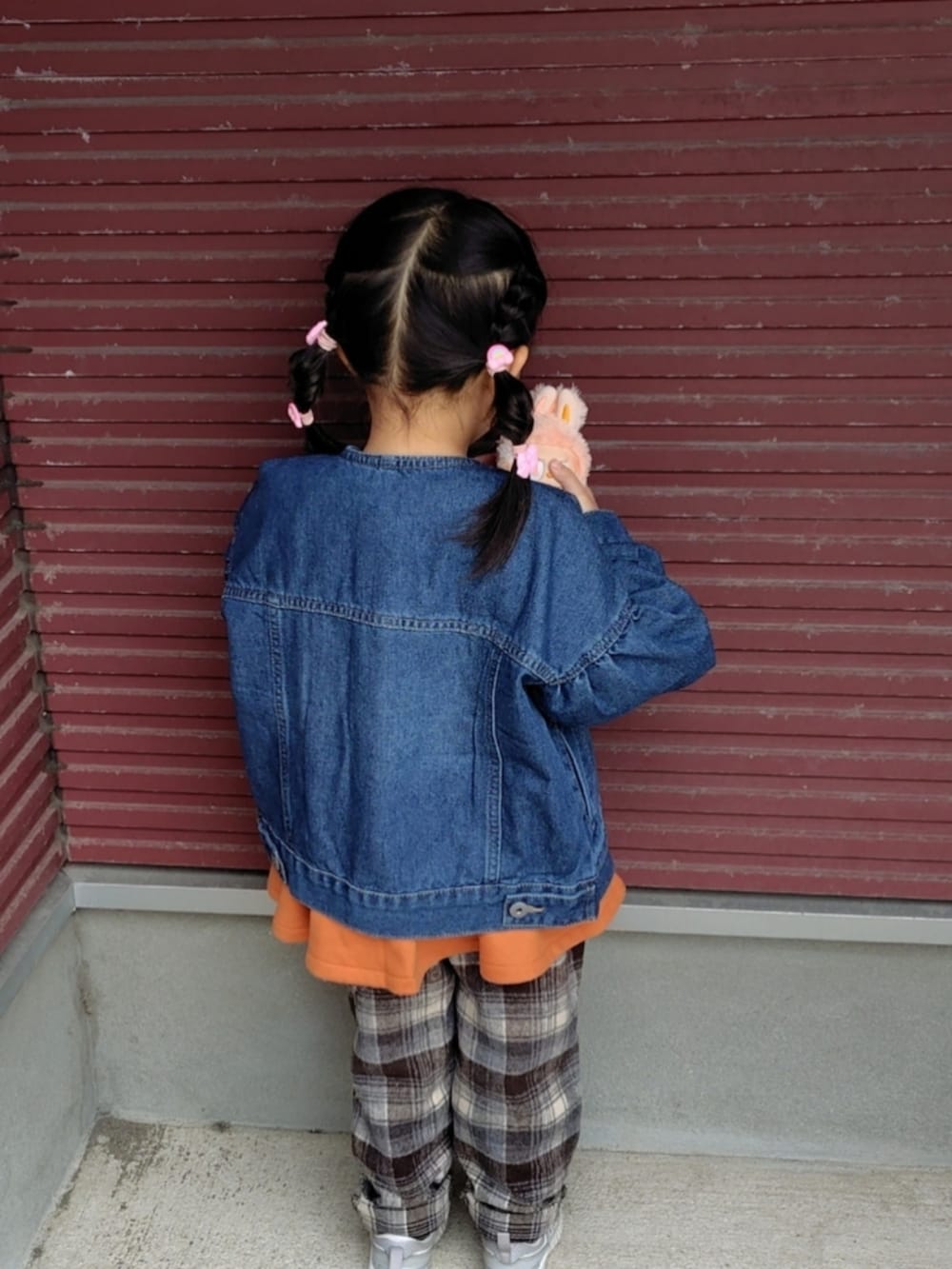 ブルー系のデニムジャケット、オレンジ系のスウェット、ブラウン系のその他パンツを着用したキッズの春コーディネートの4枚目の写真