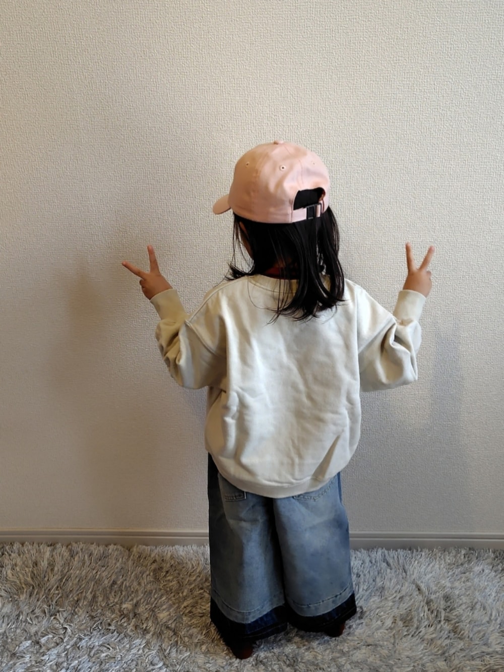 ホワイト系のスウェット、ブルー系のデニムパンツ、ブラウン系のTシャツ/カットソーを着用したキッズの冬コーディネートの4枚目の写真