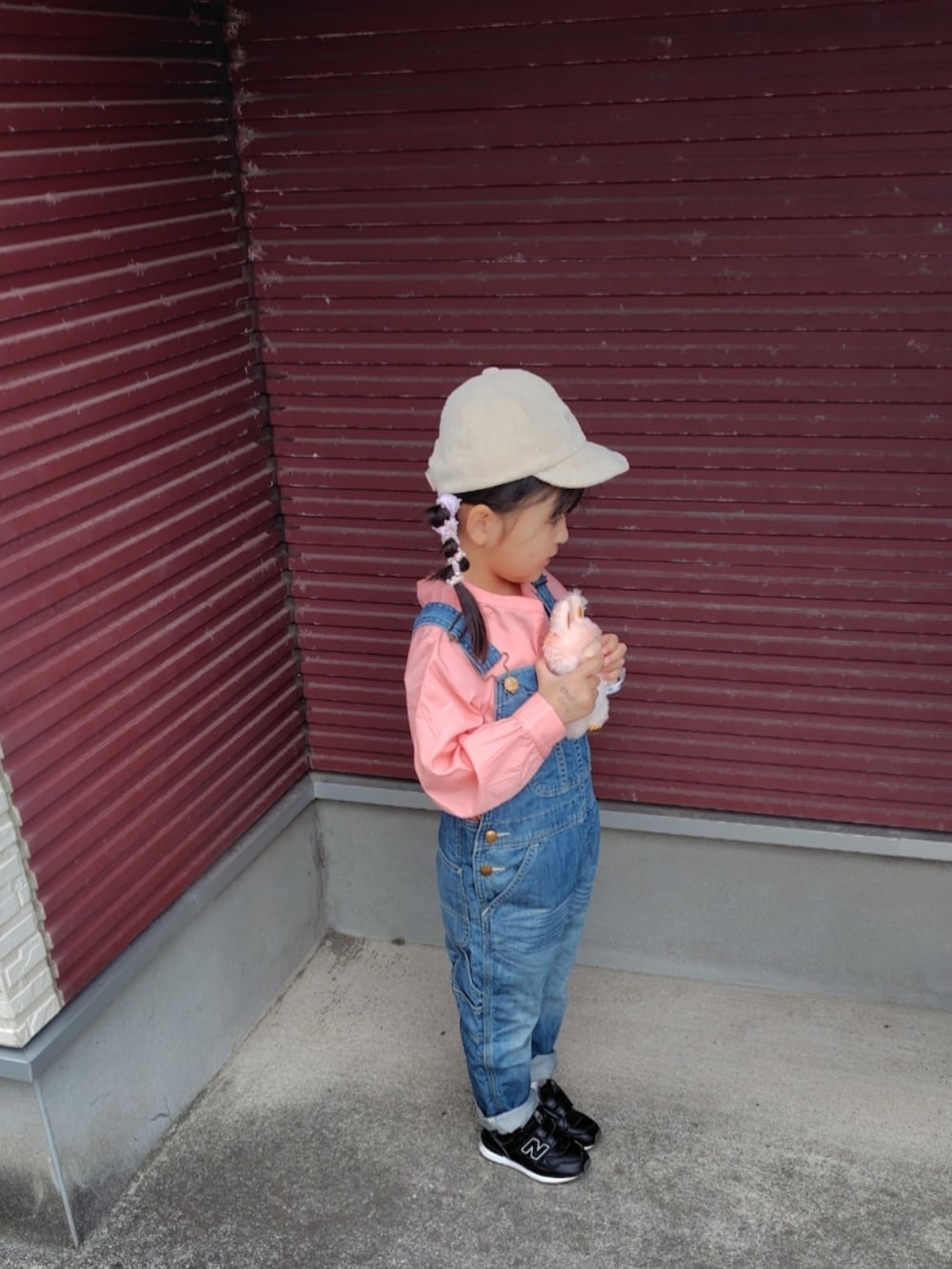 ブルー系のサロペット/オーバーオール、ピンク系のシャツ/ブラウス、ブラック系のスニーカーを着用したキッズの春コーディネートの3枚目の写真