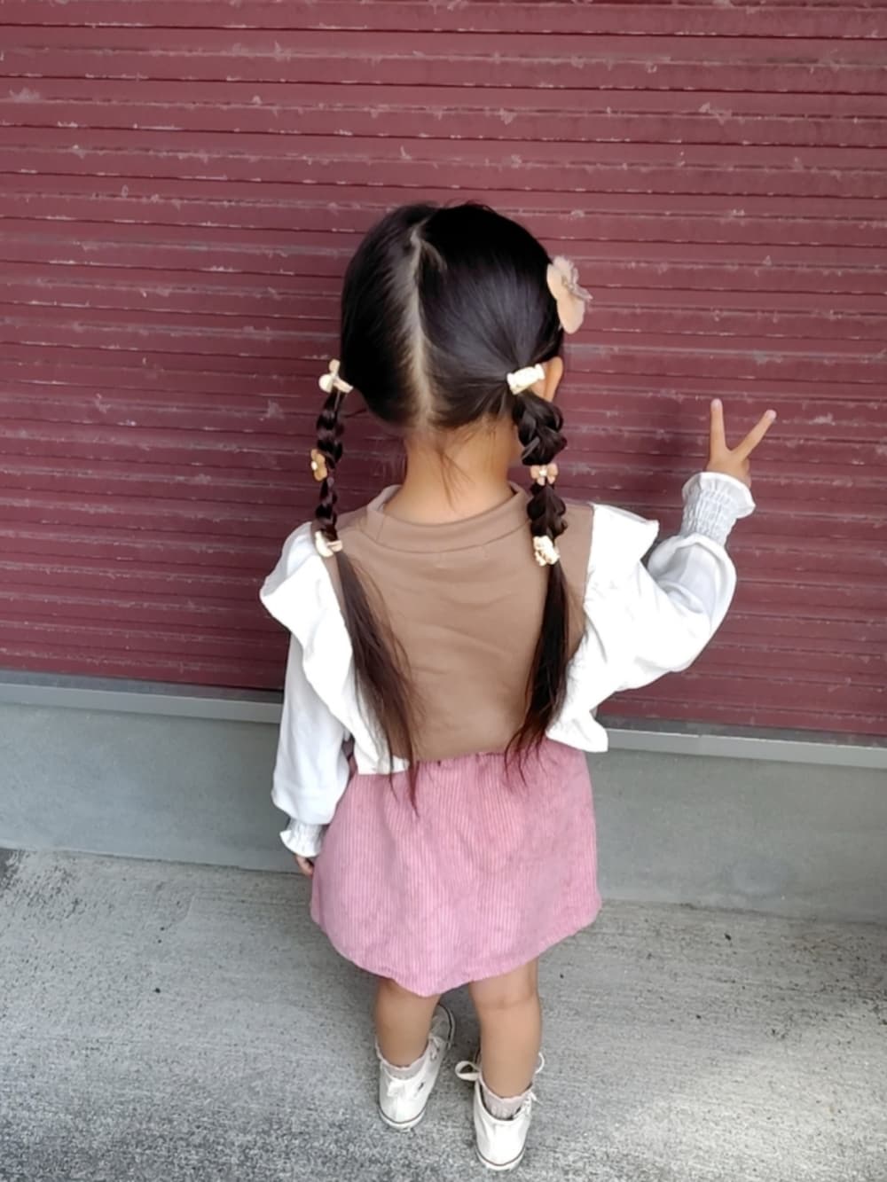 ホワイト系のスニーカー、ブラウン系のスウェットを着用したキッズの秋コーディネートの3枚目の写真