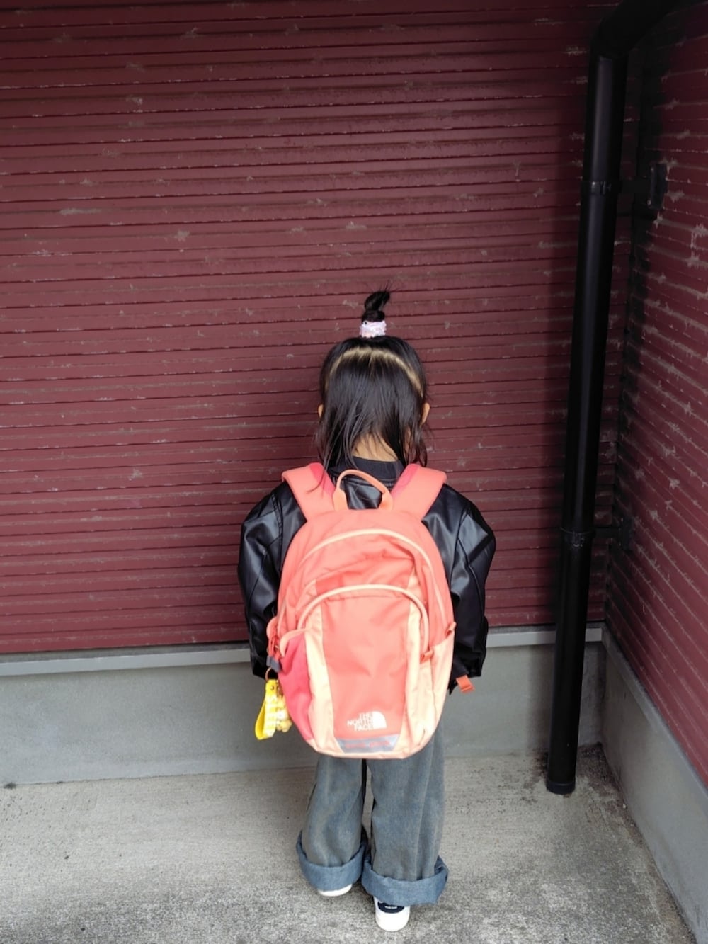 ブラック系のブルゾン、ベージュ系のスウェット、ブルー系のデニムパンツを着用したキッズの春コーディネートの3枚目の写真