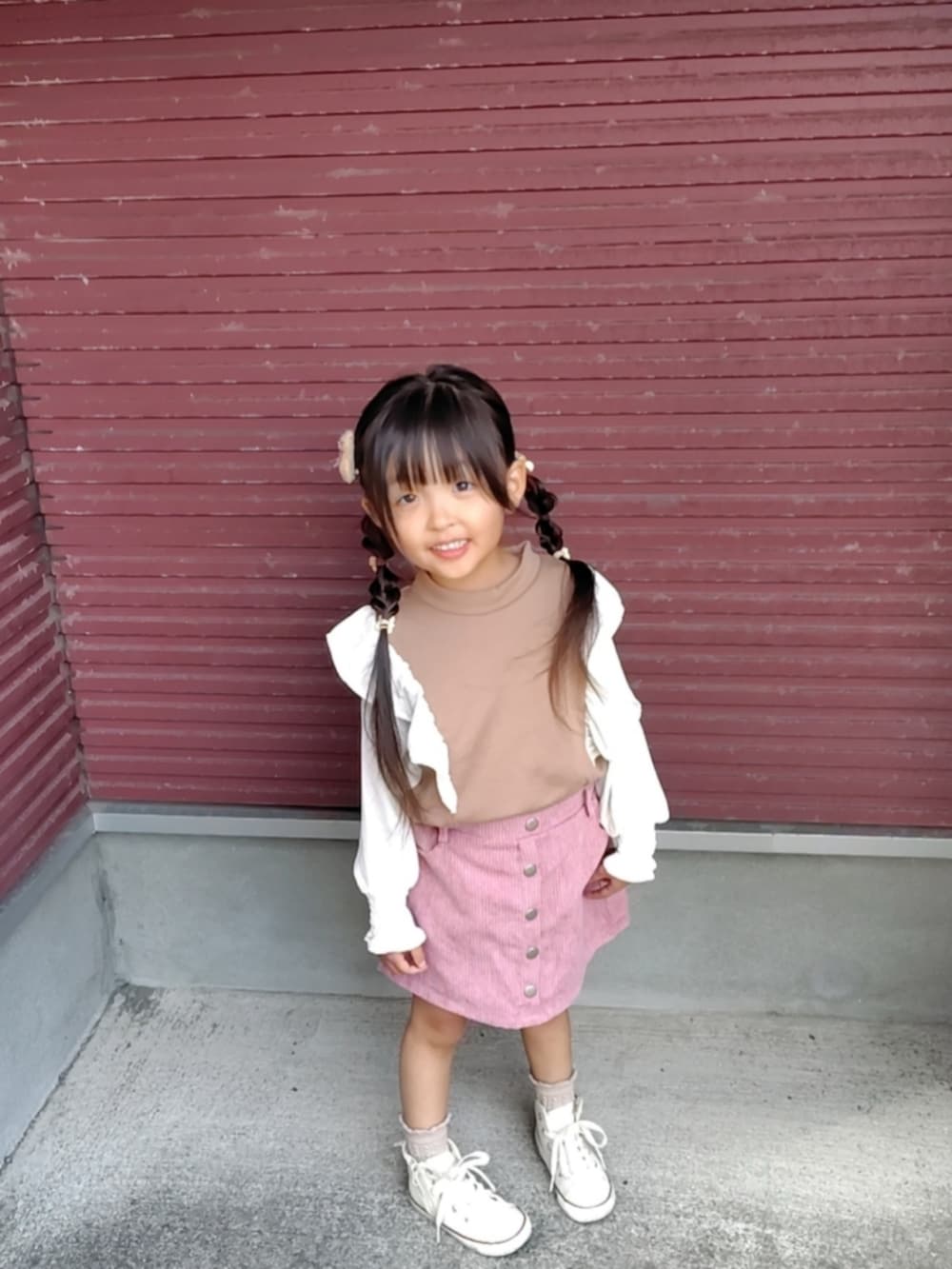 ホワイト系のスニーカー、ブラウン系のスウェットを着用したキッズの秋コーディネートの2枚目の写真