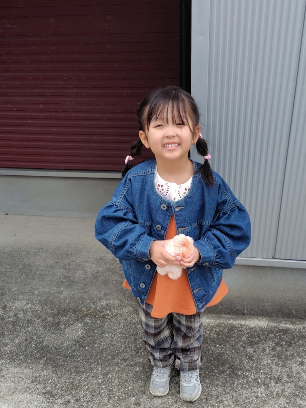 ブルー系のデニムジャケット、オレンジ系のスウェット、ブラウン系のその他パンツを着用したキッズの春コーディネートの2枚目の写真