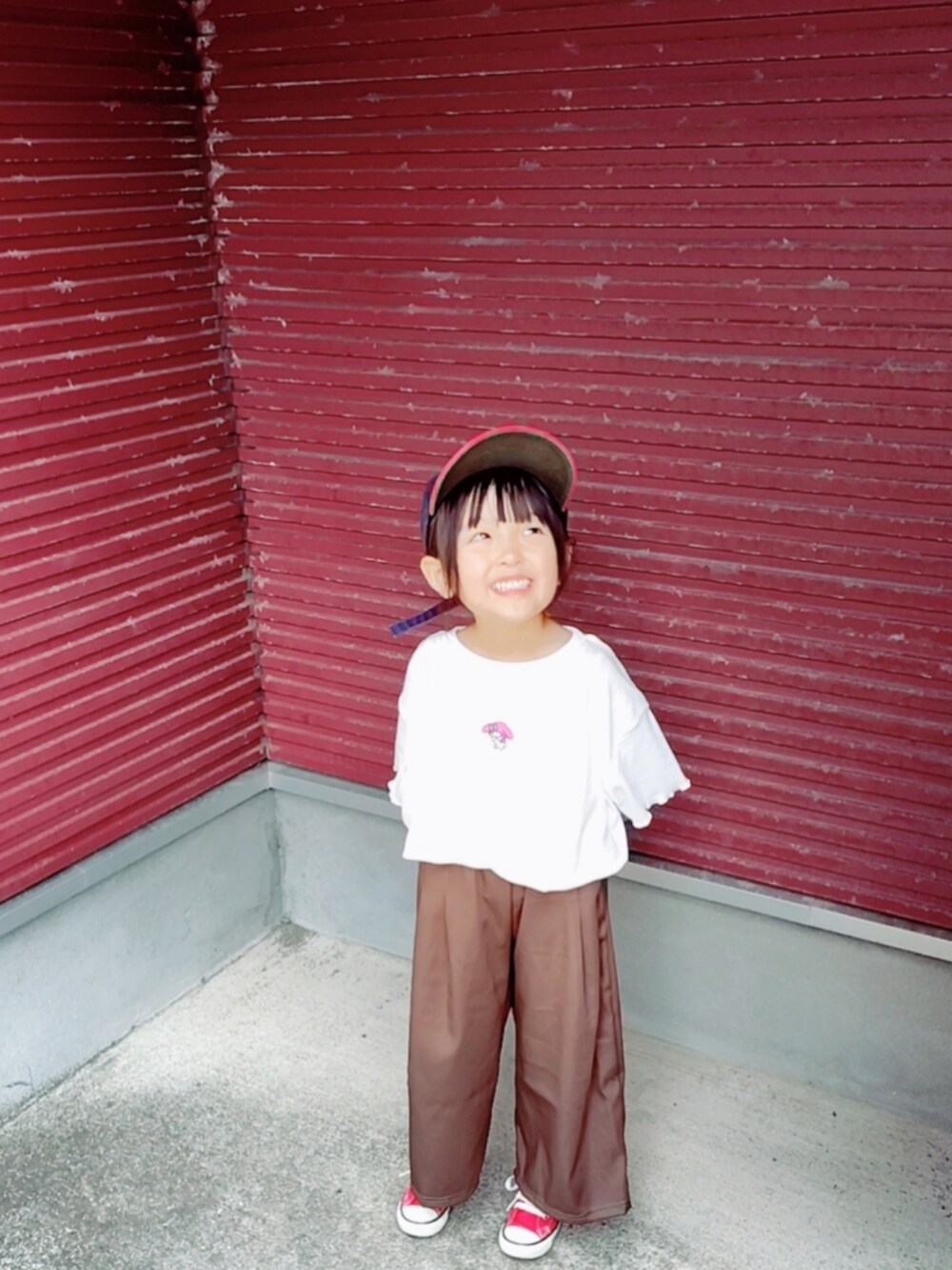 ホワイト系のTシャツ/カットソー、レッド系のスニーカー、ブルー系のキャップを着用したキッズの秋コーディネートの2枚目の写真