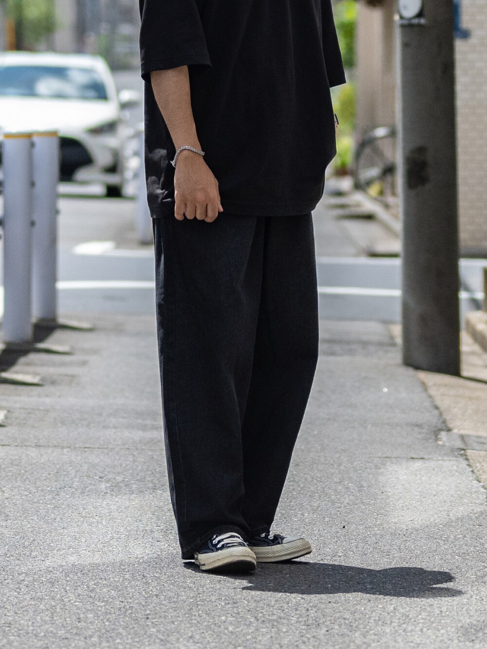 ブラック系のTシャツ/カットソー、ブラック系のスニーカーを着用したメンズの夏コーディネートの4枚目の写真