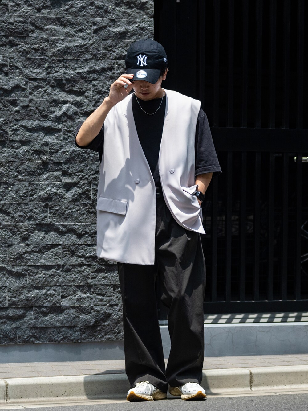 グレー系のスラックス、グリーン系のスニーカー、ブラック系のTシャツ/カットソーを着用したメンズの夏コーディネートの5枚目の写真