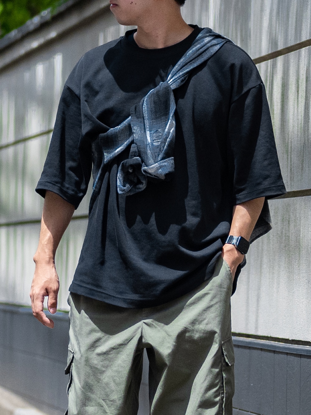 ブラック系のTシャツ/カットソー、グリーン系のカーゴパンツ、グリーン系のスニーカーを着用したメンズの夏コーディネートの2枚目の写真