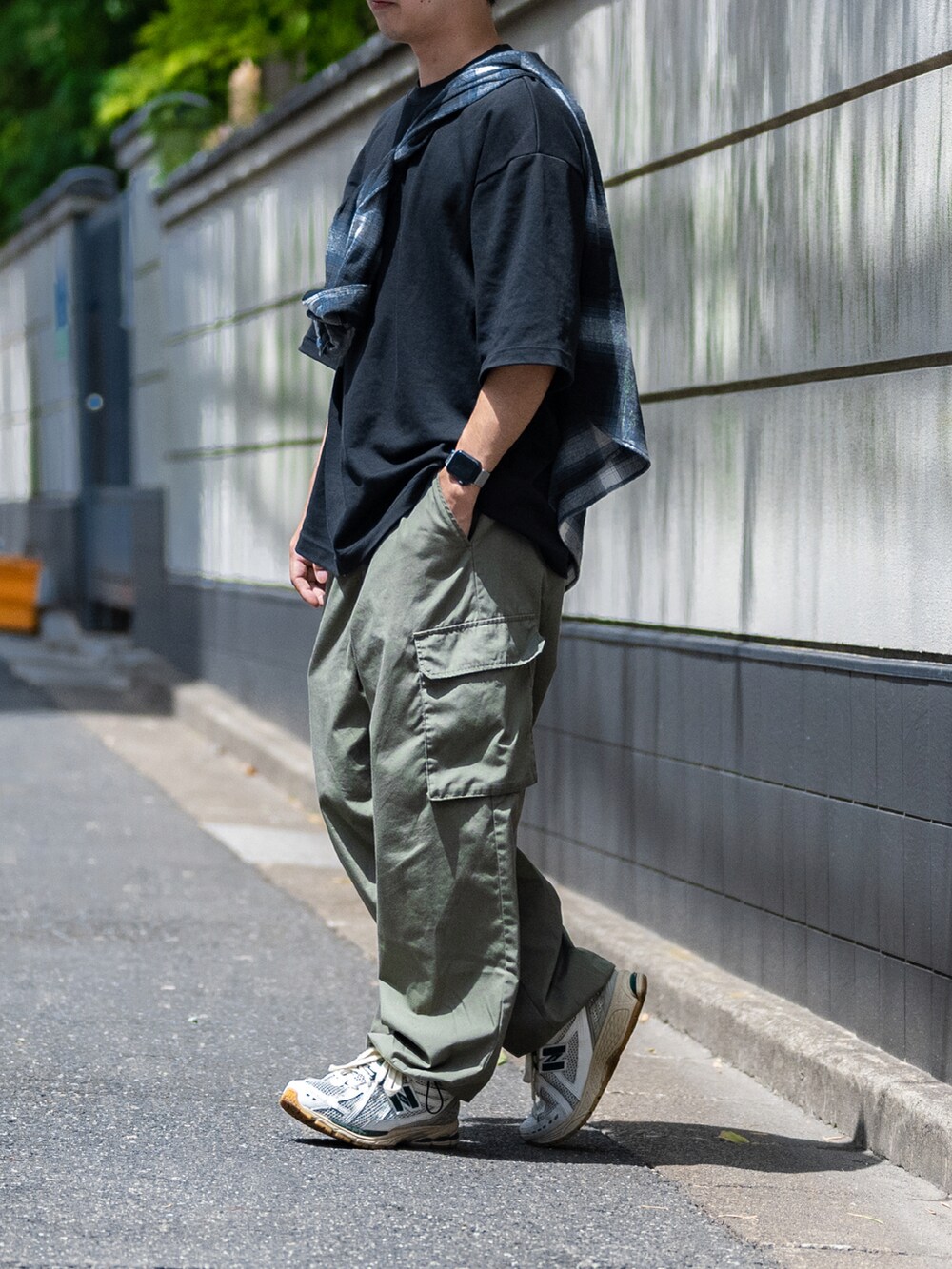 ブラック系のTシャツ/カットソー、グリーン系のカーゴパンツ、グリーン系のスニーカーを着用したメンズの夏コーディネートの3枚目の写真