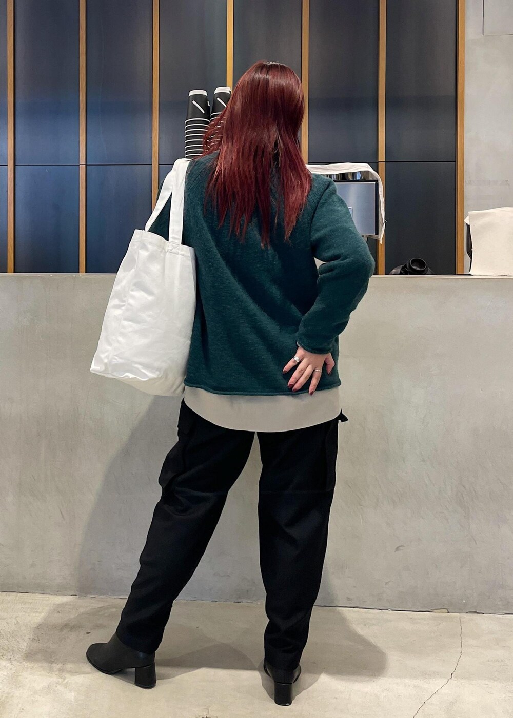 ホワイト系のトートバッグ、ベージュ系のシャツ/ブラウス、グリーン系のニット/セーターを着用したレディースの秋コーディネートの5枚目の写真