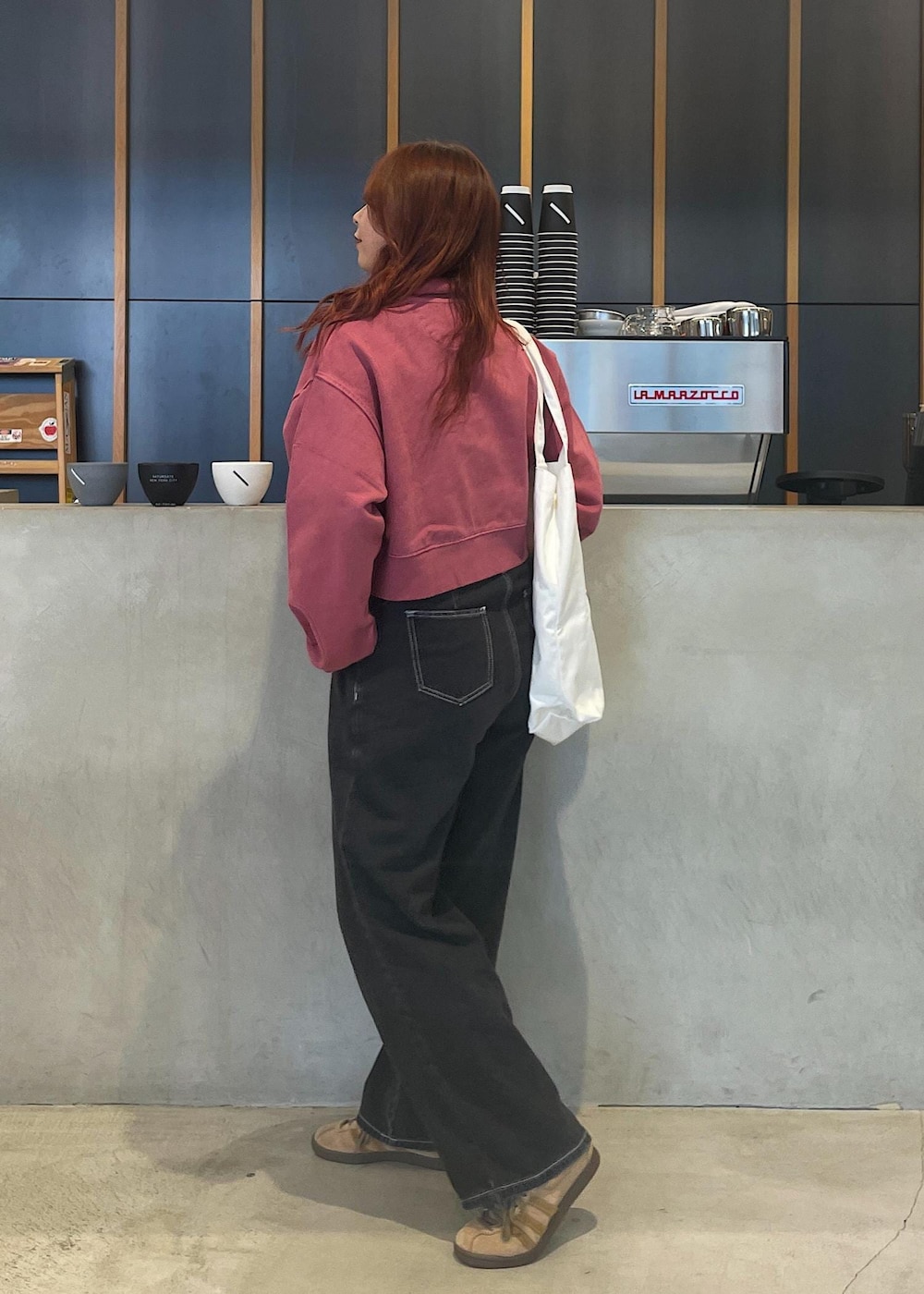 ホワイト系のトートバッグ、レッド系のスウェットを着用したレディースの夏コーディネートの3枚目の写真